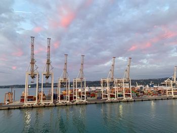 Sailboats in harbor against sky