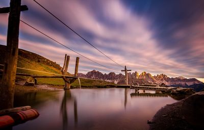 Bridge over river against cloudy sky