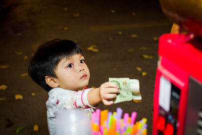 High angle view of boy holding paper currency