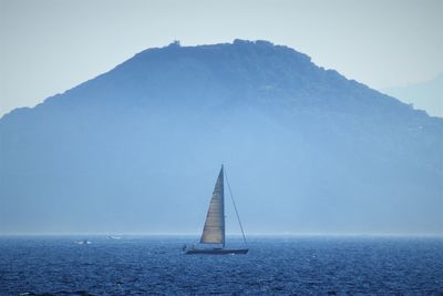 Sailboat sailing on sea against sky