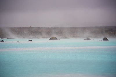 Scenic view of hot spring against sky