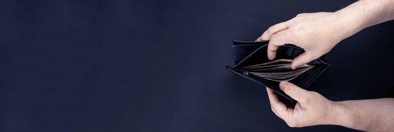 Close-up of person holding paper against black background