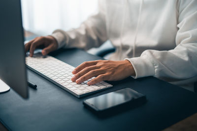 Midsection of businessman using laptop on table