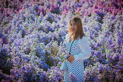Woman standing in front of flowering plants