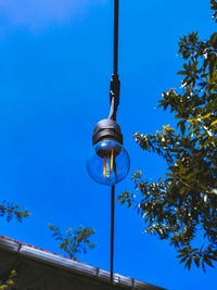 Low angle view of illuminated street light against blue sky