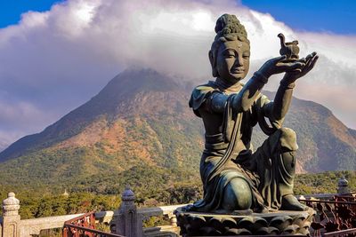 Statue of buddha against cloudy sky