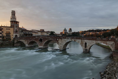 View of ponte pietra bridge at sunset