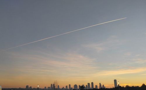 Low angle view of vapor trail against sky during sunset