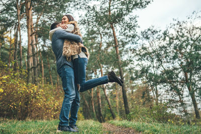 Full length of couple kissing in forest