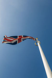 Low angle view of british flag against clear blue sky