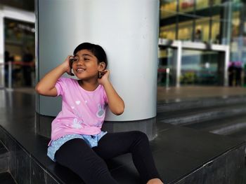 Portrait of a girl sitting in pink outdoors