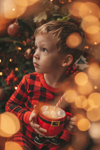 Close-up of girl blowing christmas decoration