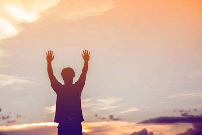 Low angle view of silhouette man standing against sky during sunset