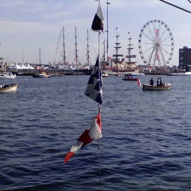 nautical vessel, transportation, water, mode of transport, boat, flag, sailboat, sea, waterfront, national flag, patriotism, sky, mast, identity, travel, american flag, flying, sailing, buoy, moored