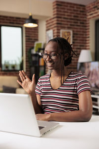 Young woman using laptop at table