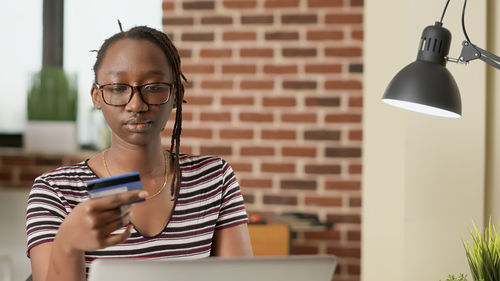 Young man using mobile phone while sitting at home