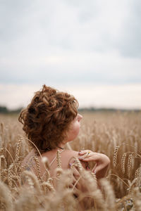 Rear view of woman on field against sky