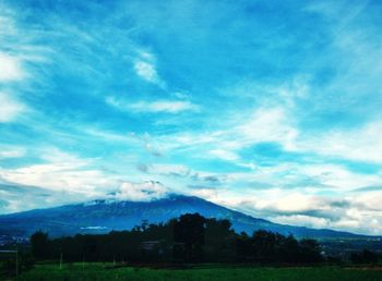 Scenic view of mountains against blue sky