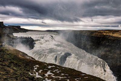 Scenic view of waterfall against sky