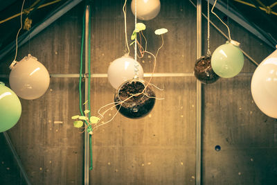 Close-up of illuminated light bulb hanging on ceiling