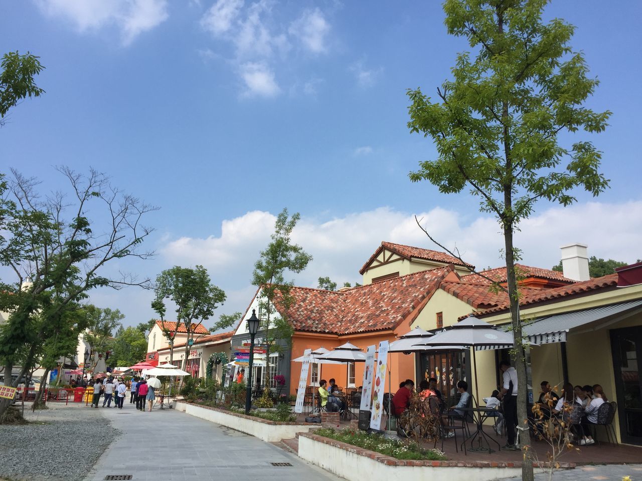 GROUP OF PEOPLE IN PARK AGAINST BUILDINGS