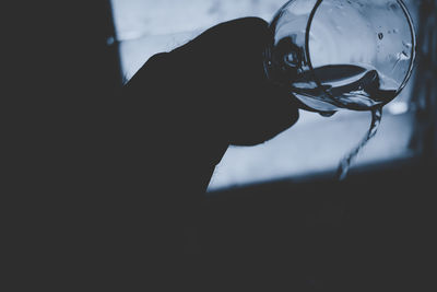 Close-up of silhouette hand holding glass