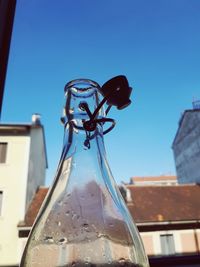 Low angle view of glass window against clear blue sky