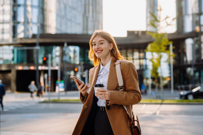 Portrait of young woman standing in city