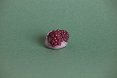 Close-up of frozen berry over green table