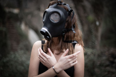 Woman wearing gas mask while covering chest