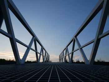 Surface level of bridge against clear blue sky