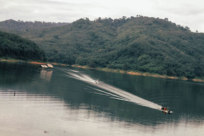 Scenic view of lake by mountain against sky