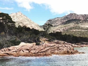 Rock formations by sea against sky