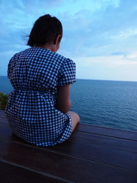 Rear view of woman looking at sea against sky