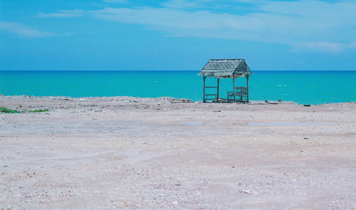 Lifeguard hut on beach against sky