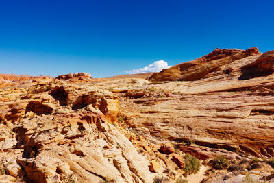 Close-up of rocky mountain against clear blue sky