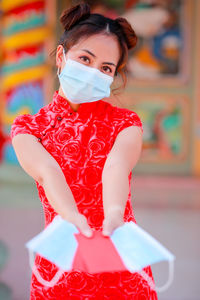 Woman wearing mask while holding papers