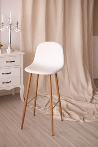 White chair with long wooden legs in the interior