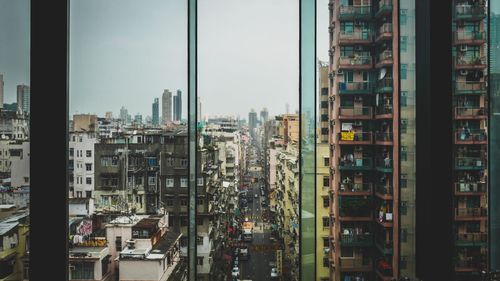 Buildings in city seen through window glass