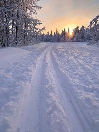 Snow covered field against sky during winter