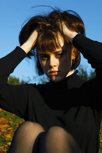 Portrait of young woman with hands in hair