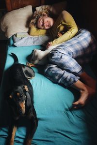 High angle view of woman with dogs in bed