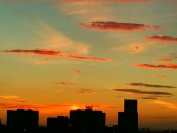 Silhouette buildings against sky during sunset