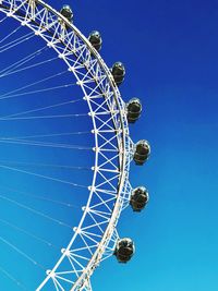 Low angle view of ferris wheel against blue sky