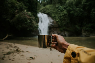 Midsection of man drinking water from pipe