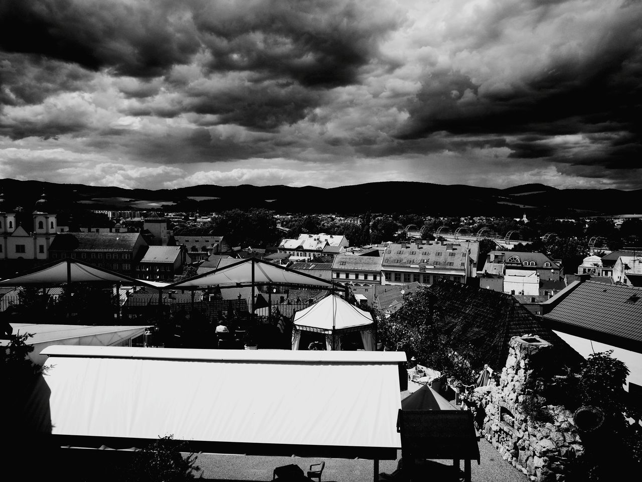 HIGH ANGLE VIEW OF HOUSES IN TOWN AGAINST CLOUDY SKY