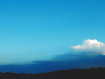 Silhouette landscape against blue sky