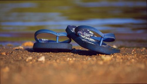 Close-up of shoes on beach