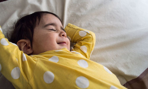 High angle view of baby girl sleeping on bed