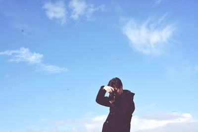 Low angle view of photographer against sky